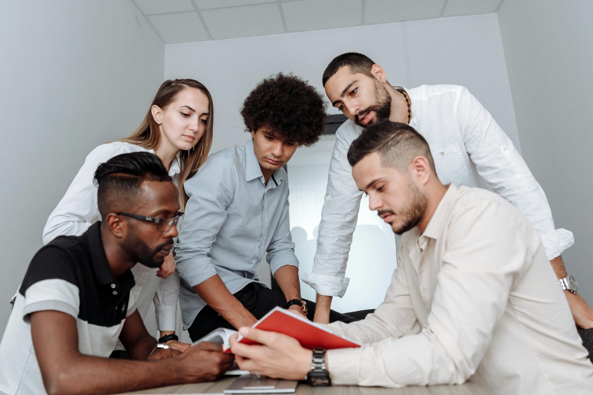 Ein multikulturelles Team nimmt an einer gemeinsamen Bürobesprechung teil und diskutiert Ideen an einem Tisch.